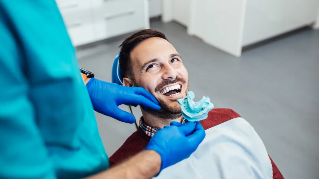 Hombre adulto mayor recibiendo prótesis dental en la Clínica Protección Oral para mejorar su salud y estética dental.